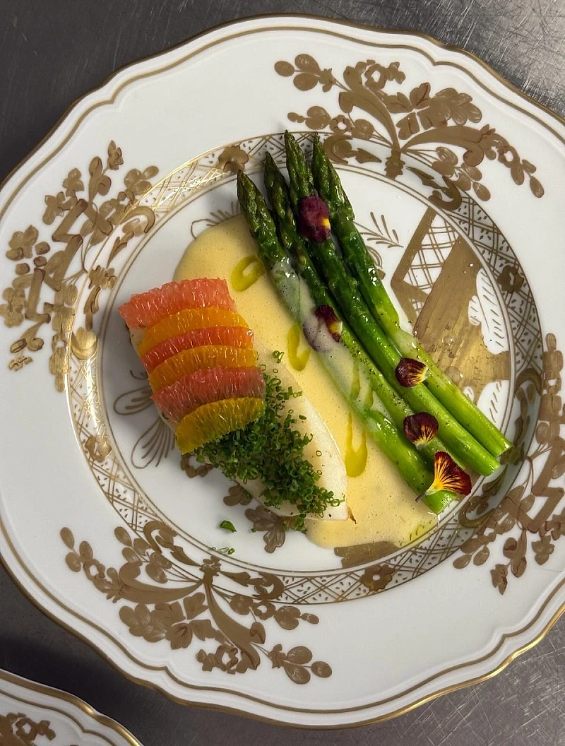 Asperges vertes et agrumes sur porcelaine à filet or — dîner gastronomique NOCTA Paris