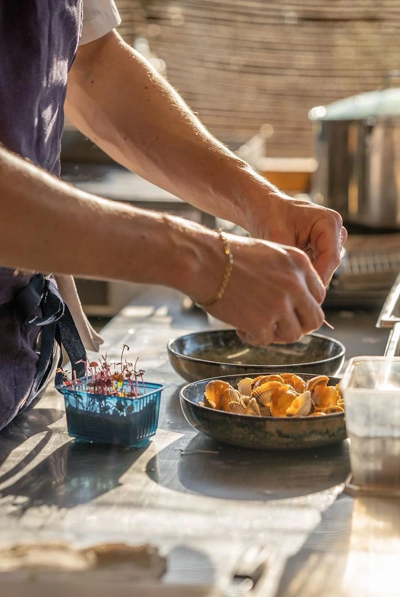 Chef Hugo en cuisine — préparation coquillages et herbes NOCTA